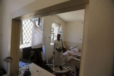 A guard is reflected in a bedroom mirror as he looks at a damage caused by an air strike by a Saudi-led coalition that struck a nearby missile base, in Yemen's capital Sanaa April 23, 2015. REUTERS/Khaled Abdullah