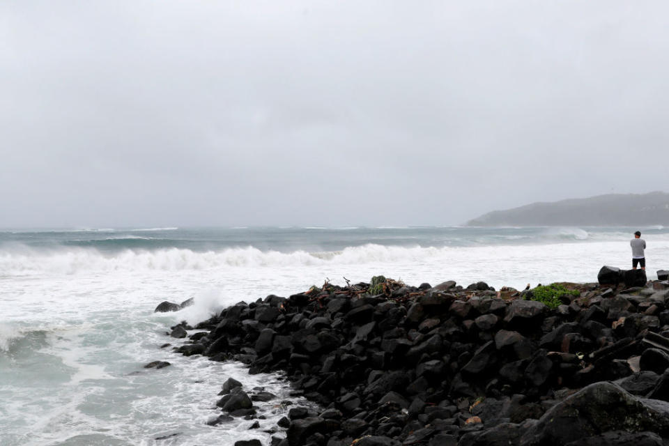 A man watches the severe swell which resulted in along stretch of beach erosion due to heavy rain on December 14, 2020 in Byron Bay, Australia. 