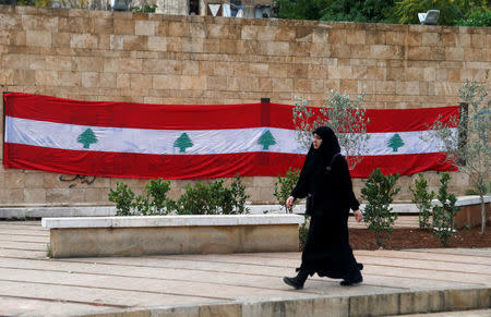 A woman walks past a Lebanese flag in Beirut, Lebanon, November 21, 2017. REUTERS/Mohamed Azakir