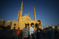 Muslim worshippers wearing masks to help stop the spread of the coronavirus, take a selfie after offered Eid al-Adha prayer outside the Mohammad al-Amin Mosque, in Beirut, Lebanon, Friday, July 31, 2020. (AP Photo/Hassan Ammar)