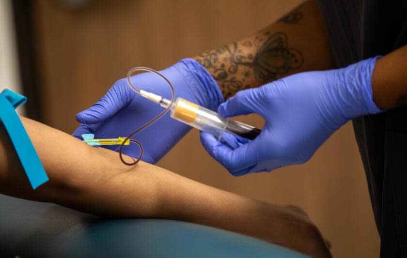 Los Angeles, CA - September 05: Phlebotomist Latrell Anderson, right, draws blood at the Aids Healthcare Foundation Wellness Center - Western on Tuesday, Sept. 5, 2023, in Los Angeles, CA. Los Angeles County's policy related to STD testing is about to change. (Francine Orr / Los Angeles Times)