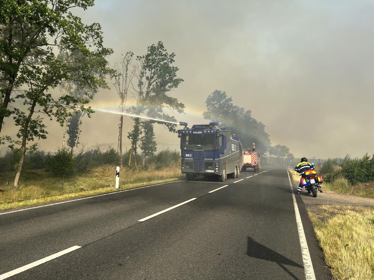 A police water cannon is in action in a forest fire in Treuenbrietzen, Germany, Sunday, June 19, 2022. 