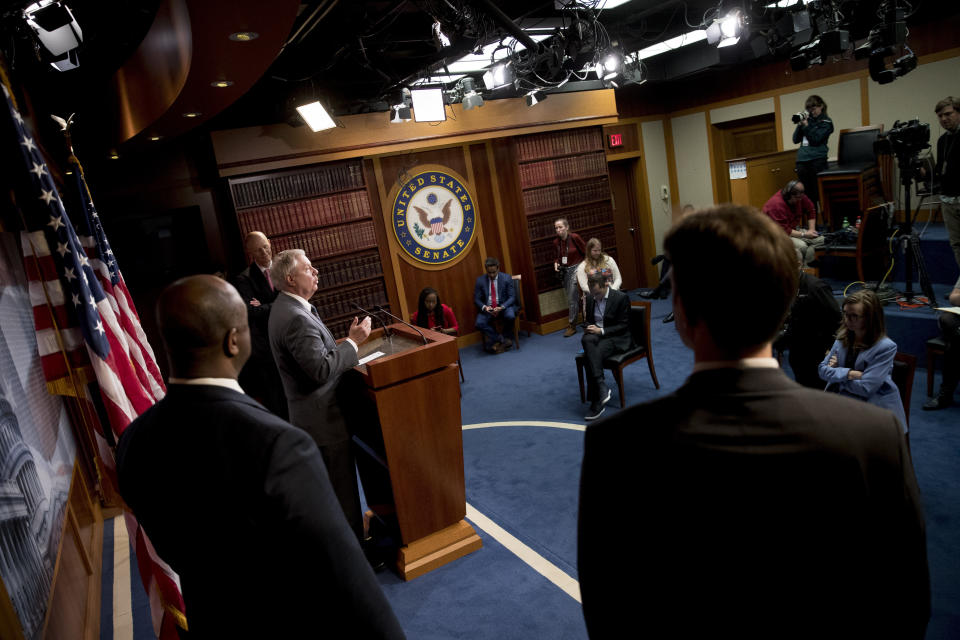 Sen. Lindsey Graham, R-S.C., third from left, accompanied by Sen. Tim Scott, R-S.C., left, Sen. Rick Scott, R-Fla., second from left, and Sen. Ben Sasse, R-Neb., right, speaks about the coronavirus relief bill on Capitol Hill in Washington, Wednesday, March 25, 2020. The senators discussed what they are calling a "drafting error" in the 2 trillion dollar stimulus bill expected to be voted on today in the Senate. (AP Photo/Andrew Harnik)