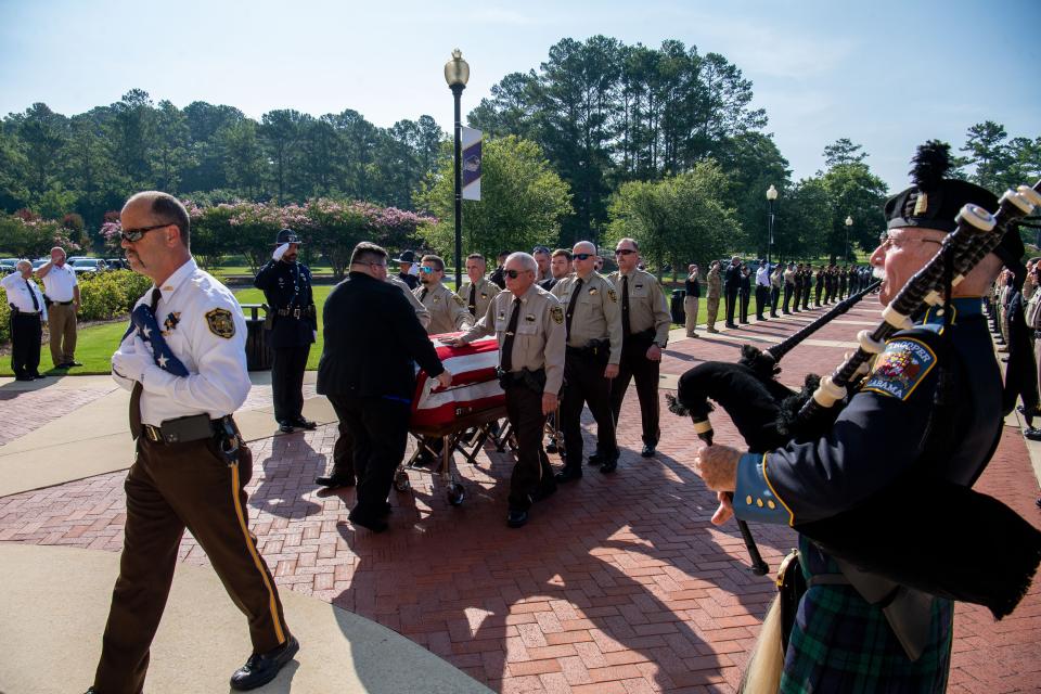 July 08, 2022; Montevallo, AL, USA; Brian Conary, retired state employee with ALEA, plays the bagpipes while the body of Bibb County Deputy Brad Johnson arrives at the University of Montevallo Student Activity Center for the visitation and funeral service.  Gary Cosby Jr.-The Tuscaloosa News
