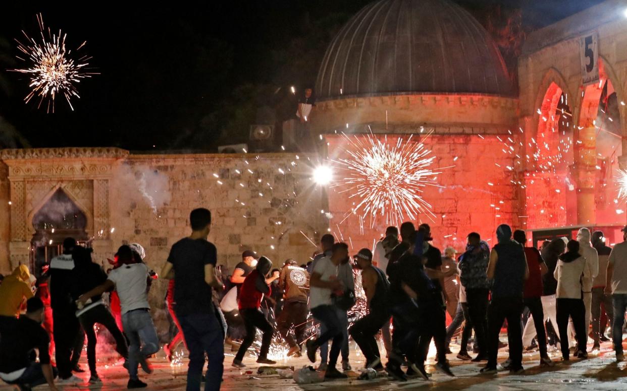  Stun grenades burst in the air amid clashes between Palestinian protesters and Israeli security forces at the al-Aqsa mosque compound in Jerusalem - AFP/AFP
