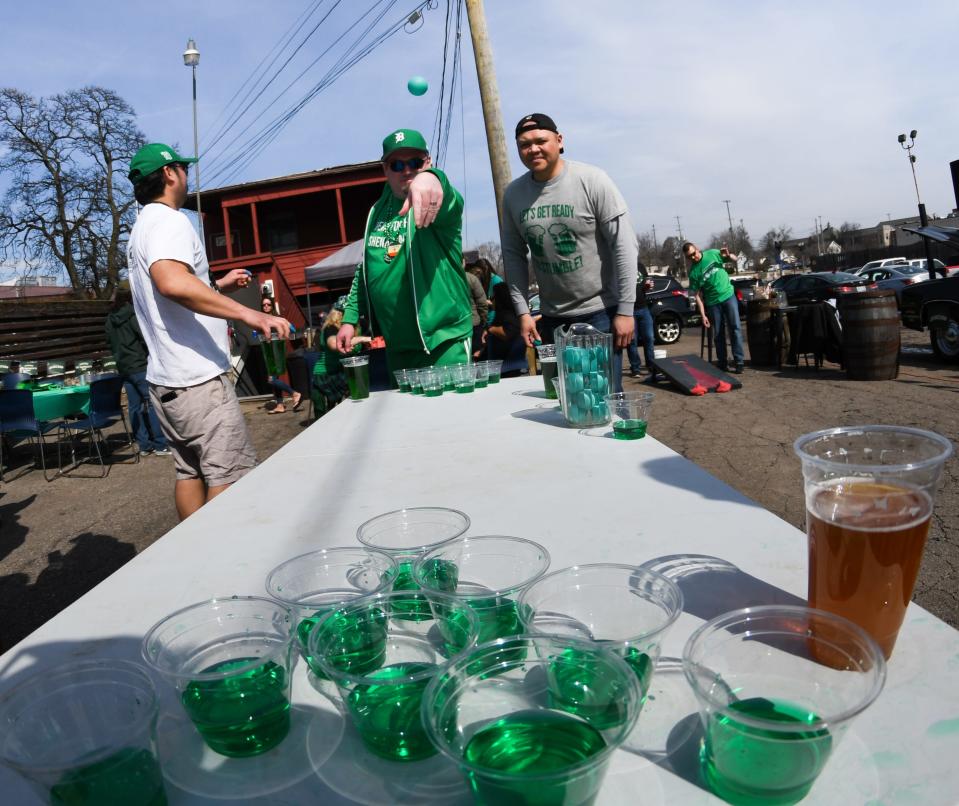 St. Patrick's Day revelers play beer pong with green beverages