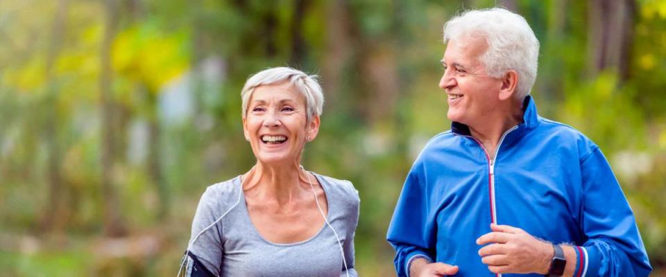 Smiling senior couple jogging in the park