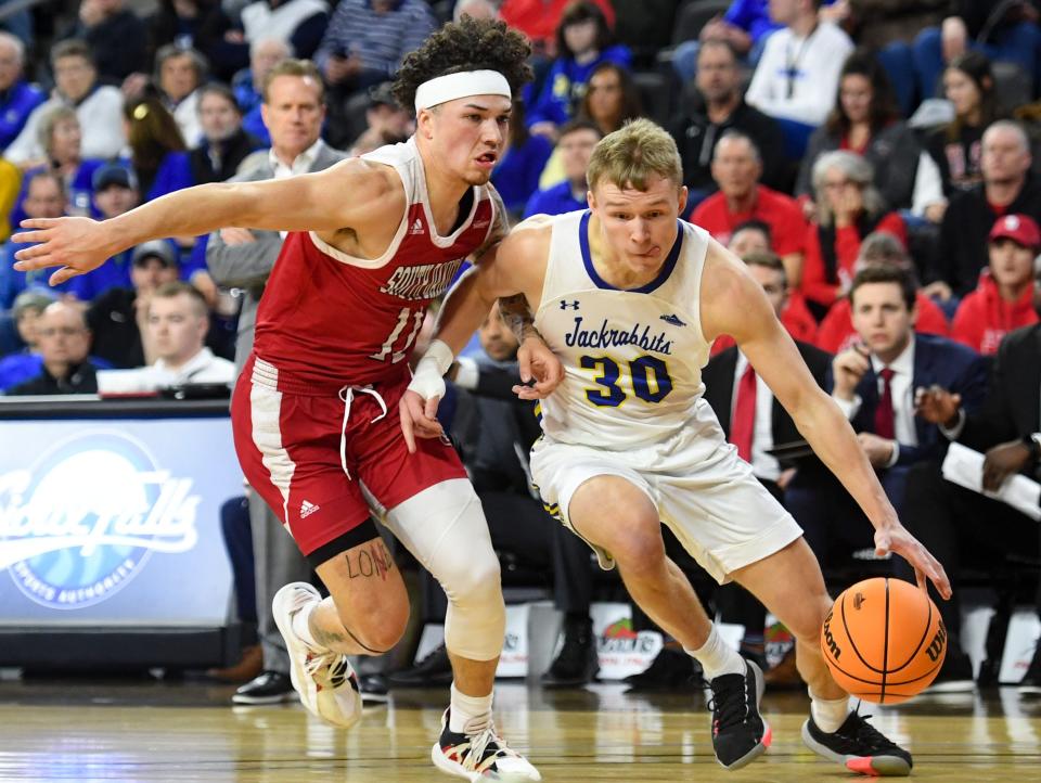 South Dakota State's Charlie Easley dribbles around South Dakota's Mason Archambault in a semifinal game on Monday, March 7, 2022, at the Summit League Tournament at the Denny Sanford Premier Center in Sioux Falls.