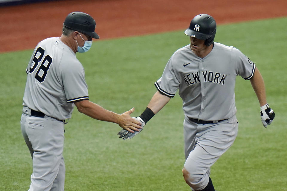 FILE- In this April 9, 2021, file photo, New York Yankees' DJ LeMahieu celebrates with third base coach Phil Nevin (88) after his home run off Tampa Bay Rays pitcher Hunter Strickland during the eighth inning of a baseball game in St. Petersburg, Fla. The Yankees announced Tuesday, May 11, 2021, that Nevin, who is fully vaccinated, has tested positive for the coronavirus. He is currently under quarantine protocol in Tampa. Under Major League Baseball’s guidance and advice, and with its assistance, additional testing and contact tracing are ongoing. (AP Photo/Chris O'Meara, File)