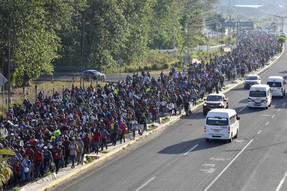 A large crowd of migrants march along a highway. (Edgar Hernandez Clemente / AP)