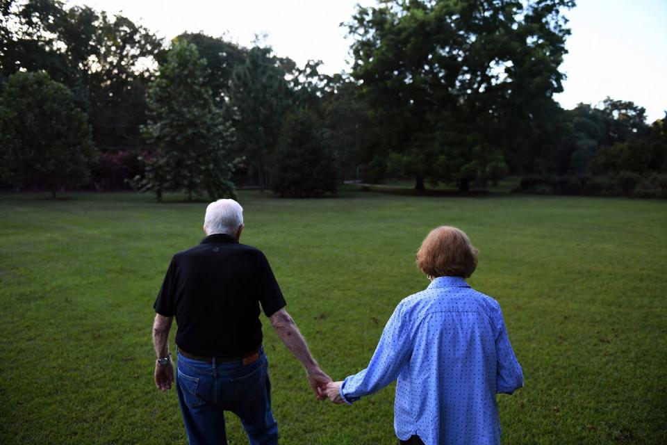 <p>Jimmy Carter walks hand-in-hand with his wife former First Lady Rosalynn Carter towards their home in Plains. </p>