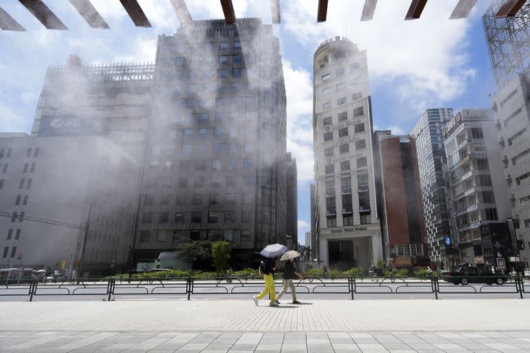 En Tokio la ciudad tiene puntos donde se rocía agua para refrescar a los caminantes (AP Photo/Eugene Hoshiko)