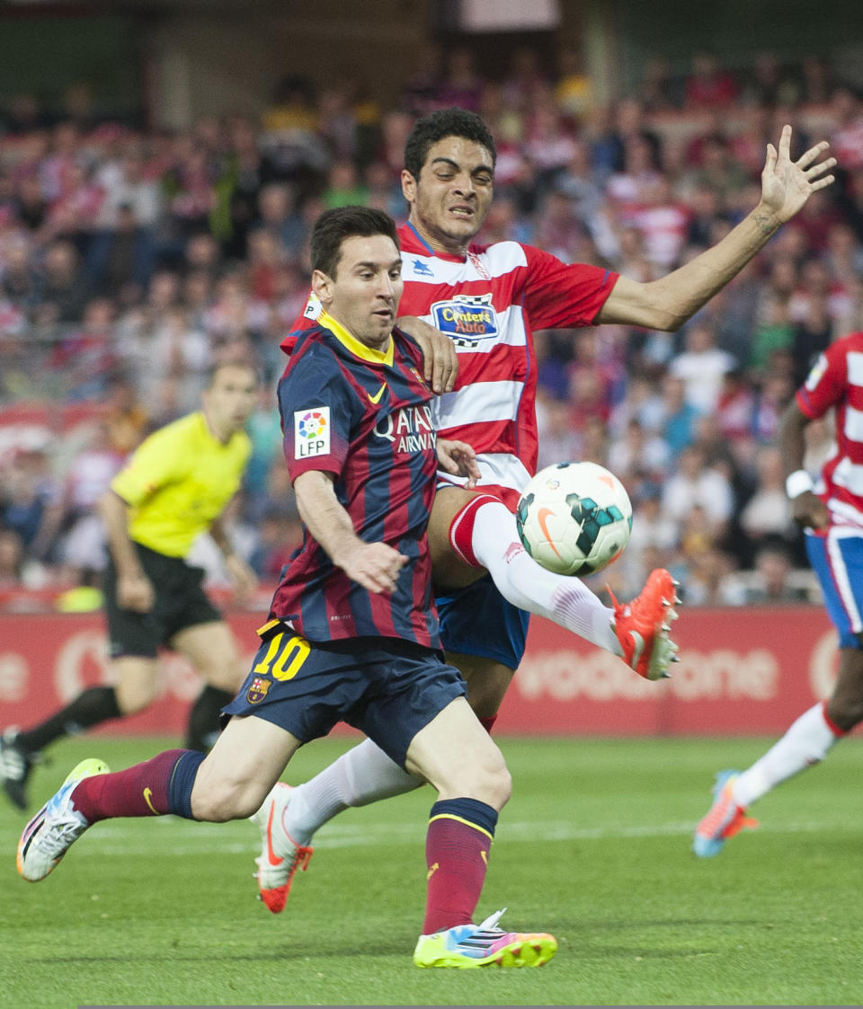 Barcelona's Lionel Messi from Argentina, left, in action with Granada's Tiago Ilori from Portugal during a Spanish La Liga soccer match between FC Granada and FC Barcelona at Los Carmenes stadium in Granada, Spain, Saturday April 12, 2014. (AP Photo/Daniel Tejedor)