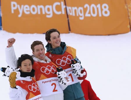 Snowboarding - Pyeongchang 2018 Winter Olympics - Men's Halfpipe Finals - Phoenix Snow Park – Pyeongchang, South Korea - February 14, 2018 - Gold medallist Shaun White of the U.S. is flanked by silver medallist Ayumu Hirano of Japan and bronze medallist Scotty James of Australia during the flower ceremony. REUTERS/Jorge Silva