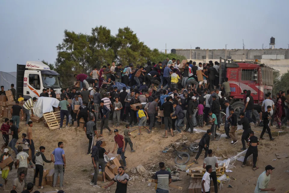 Palestinians are storming trucks loaded with humanitarian aid brought in through a new U.S.-built pier, in the central Gaza Strip, Saturday, May 18, 2024. (AP Photo/Abdel Kareem Hana)