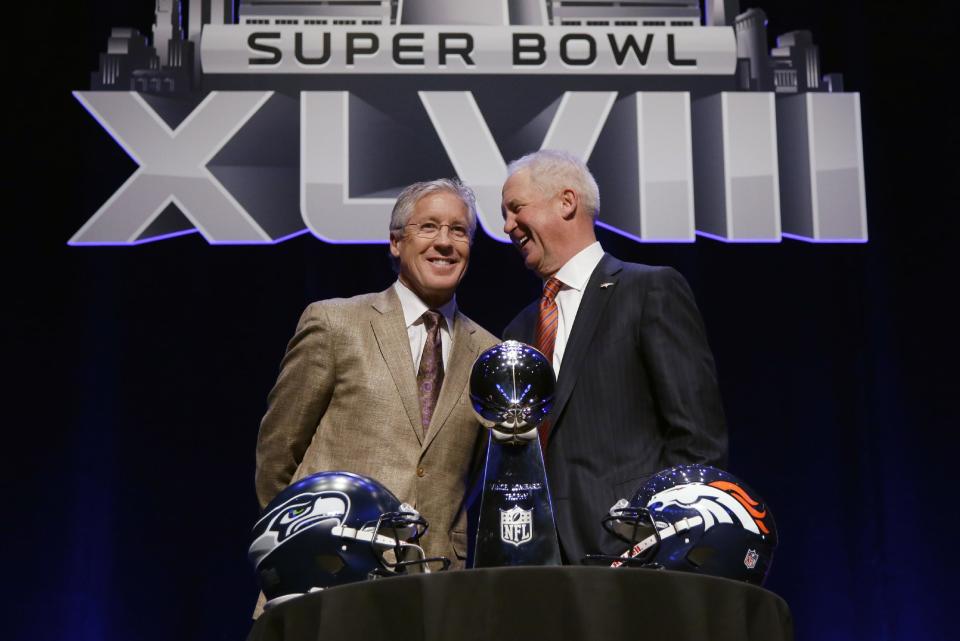 Seattle Seahawks head coach Pete Carroll, left, and Denver Broncos head coach John Fox laugh as they pose behind the Vince Lombardi Trophy before speaking at a news conference Friday, Jan. 31, 2014, in New York. The Seahawks and the Broncos are scheduled to play in the NFL Super Bowl XLVIII football game on Sunday, Feb. 2, at MetLife Stadium in East Rutherford, N.J. (AP Photo/Matt Slocum)