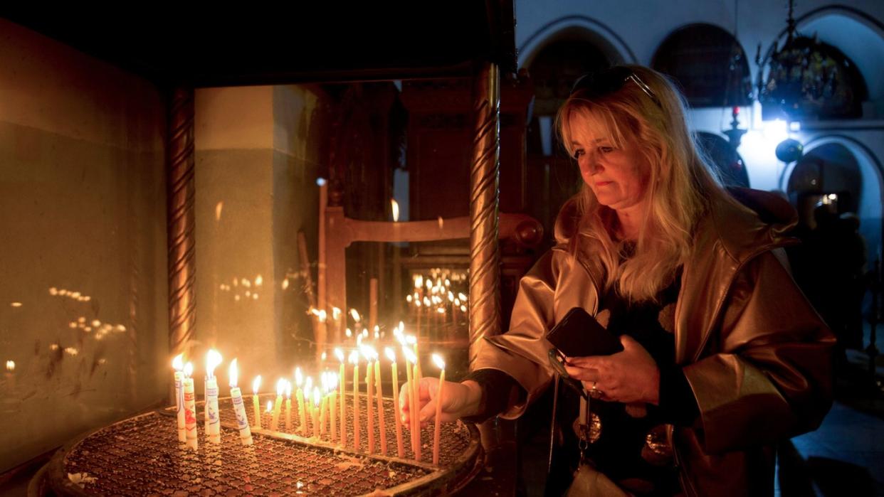 Weihnachten in Bethlehem: Eine Besucherin zündet eine Kerze in der Geburtskirche an.