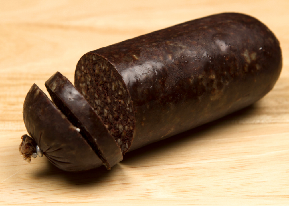 Sliced black pudding on a wooden surface.