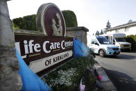 FILE - In this March 18, 2020 file photo, a vehicle leaves the Life Care Center in Kirkland, Wash. The long-term care facility was the site of the nation's first deadly COVID-19 cluster and state authorities said Wednesday that 61% of coronavirus deaths in Washington have been at long-term care facilities. (AP Photo/Elaine Thompson, File)
