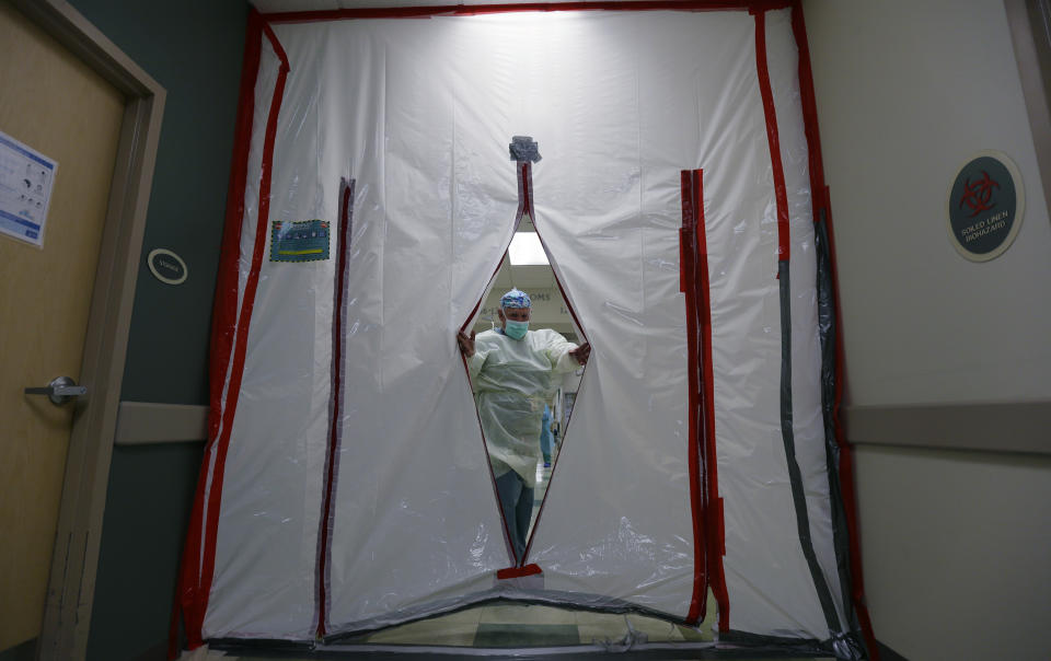 CORRECTS TO 35 HAVE DIED, INSTEAD OF 430 - Dr. Efraim Vela slips through a makeshift door to an area for pregnant women and new moms with COVID-19 at DHR Health, Wednesday, July 29, 2020, in McAllen, Texas. Nearly 15,000 pregnant women in the U.S. have tested positive for the coronavirus, and at least 35 have died, according to the Centers for Disease Control. (AP Photo/Eric Gay)