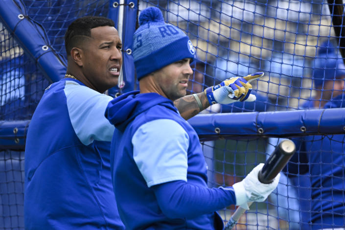 Kansas City Royals' Salvador Perez, left, and Whit Merrifield chat during batting practice before the start of their baseball game against the Cleveland Guardians, Thursday, April 7, 2022 in Kansas City, Mo. (AP Photo/Reed Hoffmann)