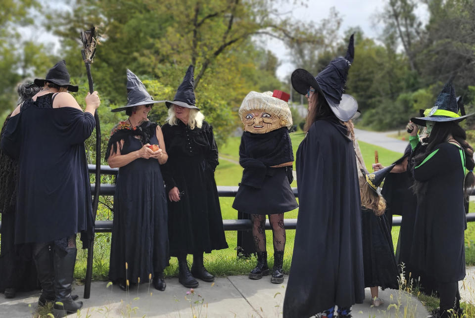 In this Sept. 16, 2023 photo, provided by Alexina Jones, people dressed as witches gather for a witches' walk in Pownal, Vt., to a newly installed marker recognizing the survivor of Vermont's only recorded witch trial. Widow Krieger was said to have escaped drowning in the Hoosic River when tried as a witch in 1785, according to the Legends and Lore marker. (Alexina Jones via AP)