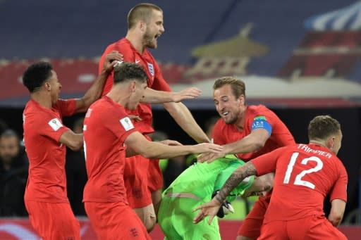 England's players mob goalkeeper Jordan Pickford after beating Colombia on penalties to reach the World Cup quarter-finals