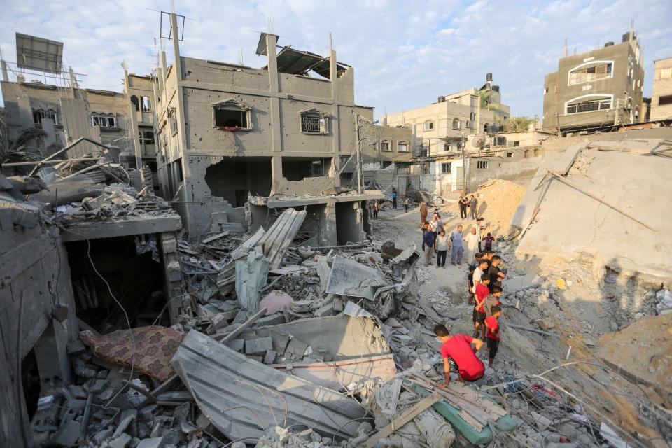 People search through buildings that were destroyed during Israeli air raids in the southern Gaza Strip on October 27 (Getty Images)