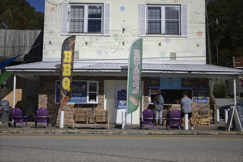 Customers wait for their order outside K-Bo's Ice Cream in Danville, W.Va., in the heart of coal country, on Tuesday, Oct. 13, 2020. Four years after Donald Trump vowed to save the dying coal industry, it has not come roaring back as the fuel has been outmatched against cheaper, cleaner natural gas and renewable energy. But many West Virginians applaud Trump's efforts and remain loyal as he seeks a second term. (AP Photo/Chris Jackson)