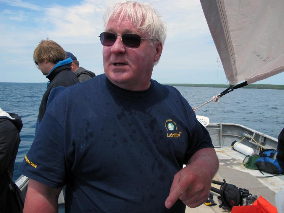 FILE - In this June 15, 2013, file photo, explorer Steve Libert speaks on a fishing boat as dive teams prepare to inspect a site in northern Lake Michigan. Libert, who has searched 30 years for the French explorer La Salle’s lost ship the Griffin, hauled a nearly 400-pound beam ashore in June. The timber has been examined by U.S. and French experts and underwent a hospital CT scan and carbon dating to determine its age and whether it once was part of a vessel. Nearly a year later, reports obtained by The Associated Press and interviews with key players reveal sharp divisions over whether the elusive ship has been found. (AP Photo/John Flesher, File)