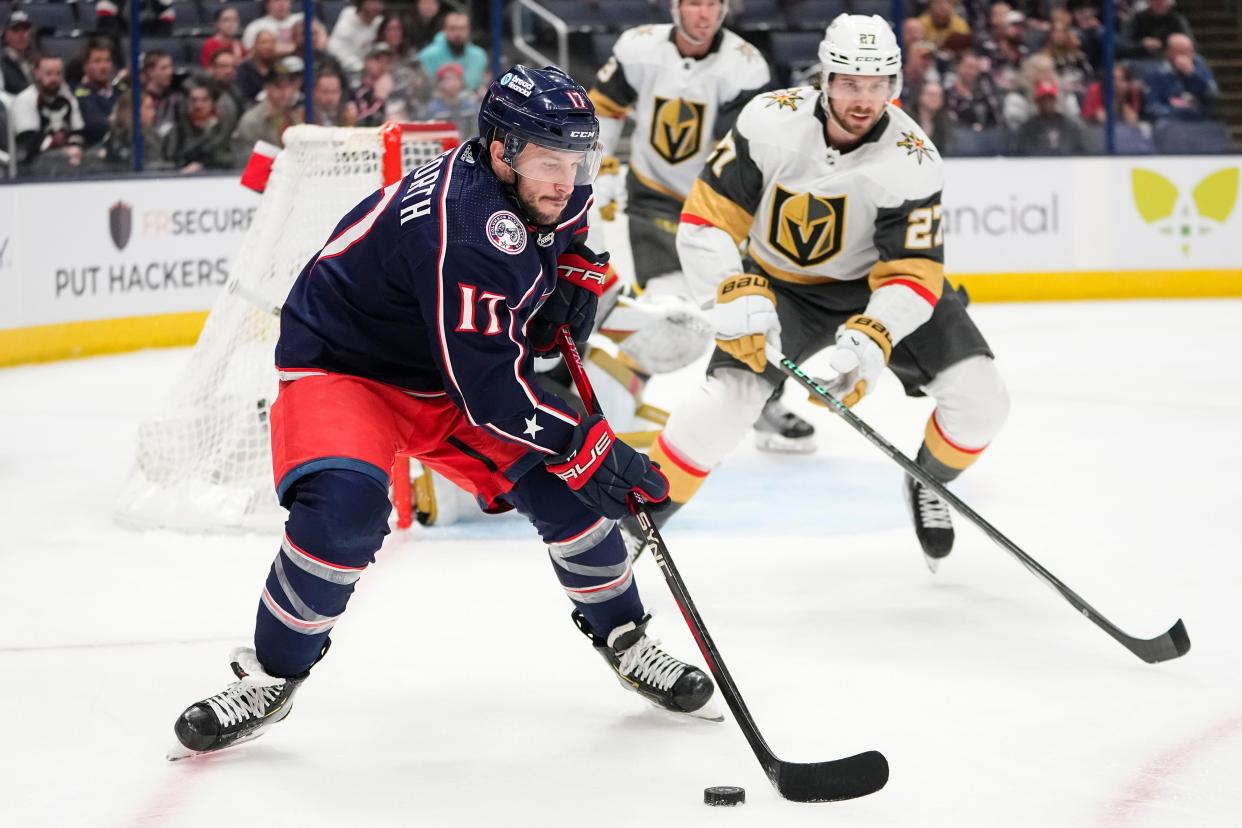 Mar 4, 2024; Columbus, Ohio, USA; Columbus Blue Jackets right wing Justin Danforth (17) controls the puck in front of Vegas Golden Knights defenseman Shea Theodore (27) during the first period of the NHL hockey game at Nationwide Arena.