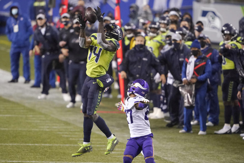 Seattle Seahawks' DK Metcalf (14) pulls in a long pass reception on the Seahawks' last series of an NFL football game as Minnesota Vikings' Cameron Dantzler defends late in the second half, Sunday, Oct. 11, 2020, in Seattle. The Seahawks won 27-26. (AP Photo/Ted S. Warren)