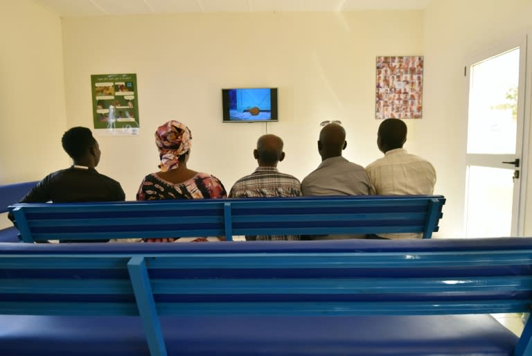 Refugees watch TV in a waiting room of UNHCR offices in Niamey, ahead of interviews by staff of the French Office for the Protection of Refugees and Stateless People