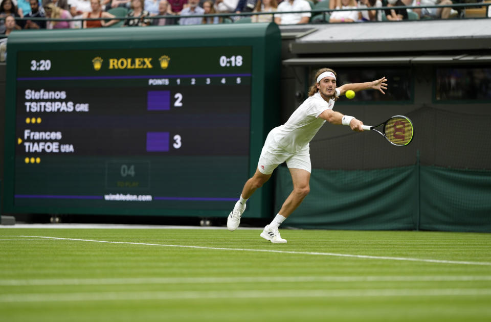 Stefanos Tsitsipas of Greece returns the ball to Frances Tiafoe of the US during the men's singles match on day one of the Wimbledon Tennis Championships in London, Monday June 28, 2021. (AP Photo/Alastair Grant)