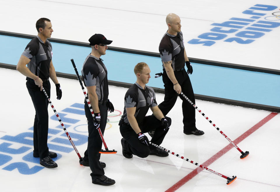 Canada's, from left, E.J. Harnden, Ryan Harnden, skip Brad Jacobs, and Ryan Fry, look over they next shot during men's curling competition against Norway at the 2014 Winter Olympics, Friday, Feb. 14, 2014, in Sochi, Russia. (AP Photo/Robert F. Bukaty)