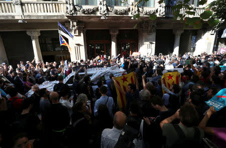 A crowd of protesters gather outside the Catalan region's economy ministry after junior economy minister Josep Maria Jove was arrested by Spanish police during a raid on several government offices, in Barcelona, Spain, September 20, 2017. REUTERS/Albert Gea