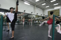 In this photo taken Nov. 25, 2012, Filipino slum dweller Jamil Montebon, left, practices steps during a class at Ballet Manila in the Philippine capital. Montebon, a scholar at Ballet Manila's program, used to collect garbage and also worked at a junk shop. He now receives a monthly stipend, stays at their dormitory and is given meals. (AP Photo/Aaron Favila)