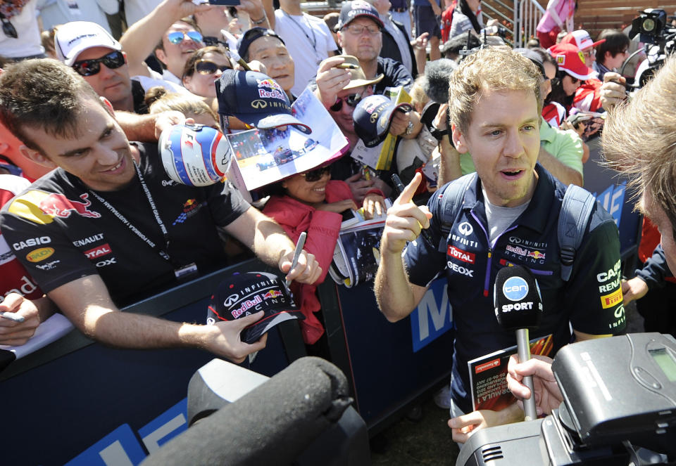 Red Bull driver Sebastian Vettel of Germany chats as he signs autographs for fans at Albert Park ahead of the Australian Formula One Grand Prix in Melbourne, Australia, Thursday, March 13, 2014. (AP Photo/Andrew Brownbill)