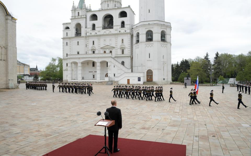 FILE - In this file photo taken on Saturday, May 9, 2020, Russian President Vladimir Putin, back to a camera, watches the honour guard of the Presidential Regiment march on Cathedral Square in the Kremlin marking the 75th anniversary of the Nazi defeat in World War II in Moscow, Russia. A massive military parade that was postponed by the coronavirus will roll through Red Square this week to celebrate the 75th anniversary of the end of World War II in Europe, even though Russia is continuing to register a steady rise in infections. (Alexei Druzhinin, Sputnik, Kremlin Pool Photo via AP, File)