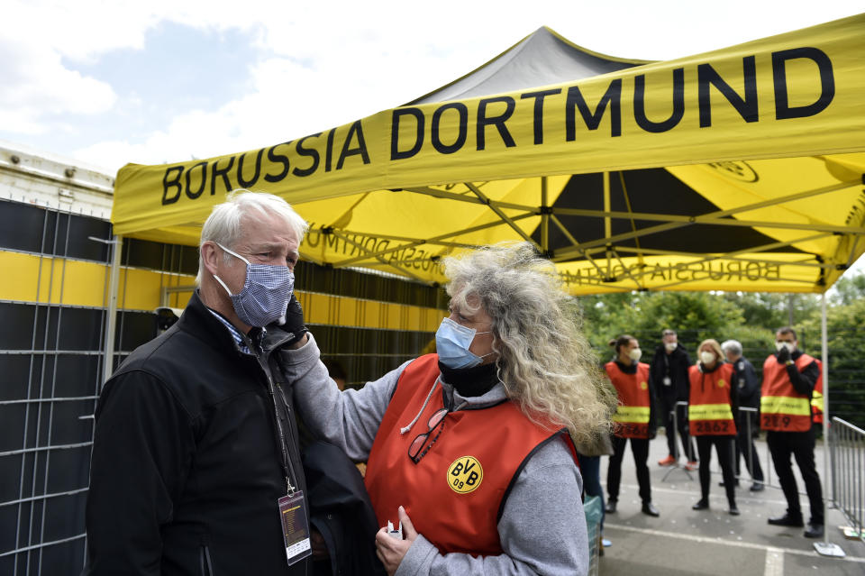 A TV crew member has his temperature checked before entering the stadium for the German Bundesliga soccer match between Borussia Dortmund and Schalke 04 in Dortmund, Germany. (Photo by Martin Meissner/PA Images via Getty Images)