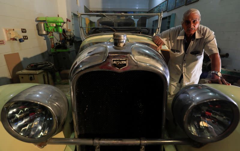 Sayed Sima, a 70-years-old Egyptian collector of vintage car, stands next to a 120-year-old American "1900 Auburn" automobile in his store, the Giza suburb of Abu Rawash