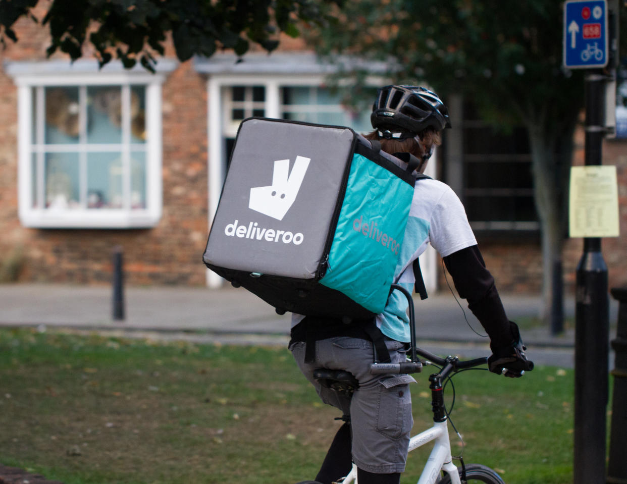 York, UK - September 28, 2016.A cyclist from the increasingly popular take away delivery company Deliveroo speeding through city streets with a hot food delivery from take aways and restaurants to homes.