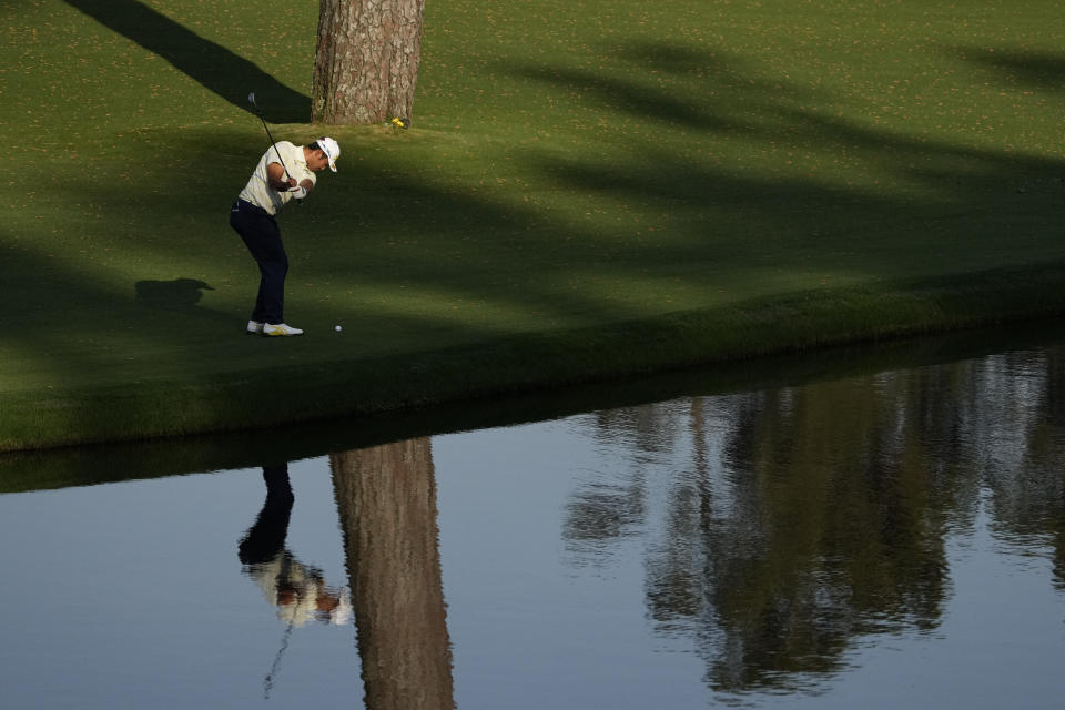 Hideki Matsuyama, of Japan, chips to the green on the 15th hole after putting his approach shop into the water during the final round of the Masters golf tournament on Sunday, April 11, 2021, in Augusta, Ga. (AP Photo/Gregory Bull)