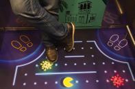 A man stands in an elevator decorated with a graphic showing the video game character Pac-Man eating the coronavirus at the Rove City Centre Hotel in Dubai, United Arab Emirates, Monday, July 6, 2020. Dubai reopened for tourists Tuesday amid the coronavirus pandemic, hoping to reinvigorate a vital industry for this city-state before its crucial winter tourist season. (AP Photo/Jon Gambrell)