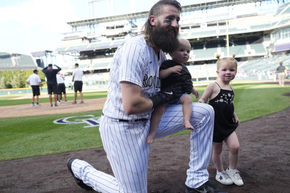 Colorado Rockies' Charlie Blackmon poses with his children for a photo after the Rockies' victory in 11 innings over the Minnesota Twins in the final, regular-season baseball game Sunday, Oct. 1, 2023, in Denver. (AP Photo/David Zalubowski)