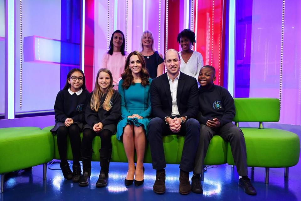 Prince William and Kate Middleton pose with parents and children who gave feedback on an app designed to combat online bullying during a visit to the BBC in London