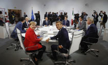 French President Emmanuel Macron, center, U.S. President Donald Trump, right, Japan's Prime Minister Shinzo Abe, second right, Britain's Prime Minister Boris Johnson, second left, German Chancellor Angela Merkel , center left, Canada's Prime Minister Justin Trudeau, Italy's Prime Minister Giuseppe Conte, rear right, and European Council President Donald Tusk attend a G7 working session on "International Economy and Trade, and International Security Agenda" during the G7 summit in Biarritz, southwestern France, Saturday Aug. 25, 2019. (Philippe Wojazer/Pool via AP)