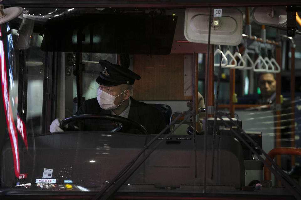 A bus driver wearing a mask leaves a bus stop Thursday, Jan. 30, 2020, in Tokyo. The country began evacuating Japanese citizens on Wednesday from the Chinese city Wuhan hardest-hit by the virus. (AP Photo/Jae C. Hong)