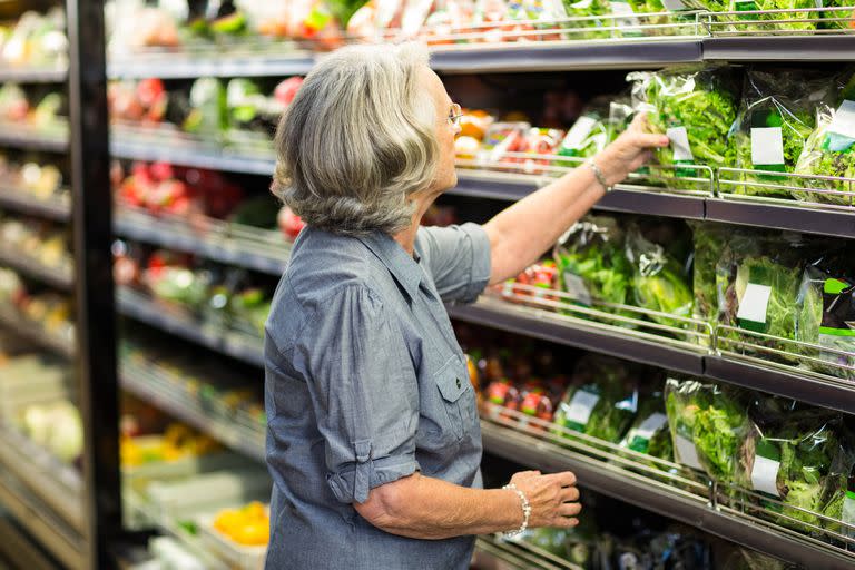 Senior woman picking out some vegetables in supermarket