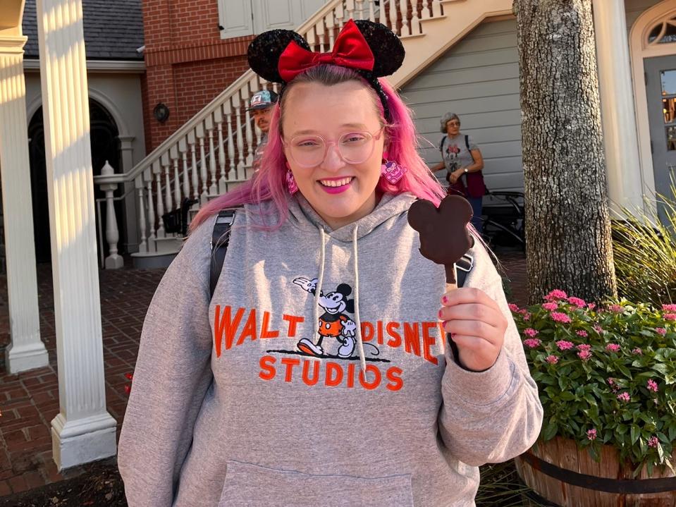 casey posing holding a mickey ice cream bar at disney world